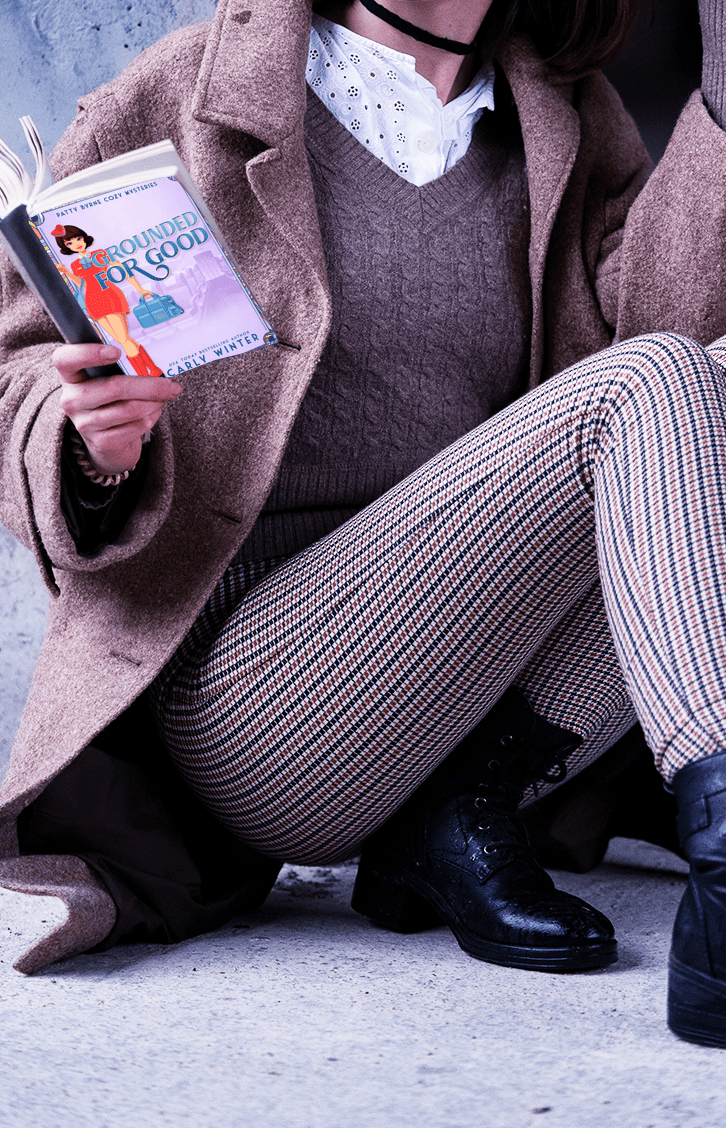 woman reading grounded for good historical cozy mystery paperback by carly winter
