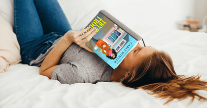 Woman reading Thyme and Trouble paperback by Carly Winter 