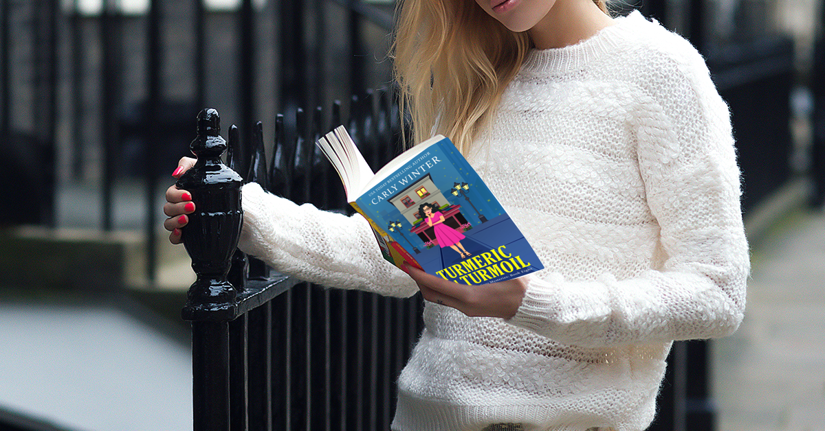woman reading a paperback of  turmeric and turmoil by carly winter